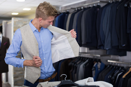 Adult male choosing waistcoat in the store