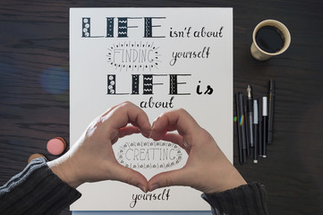Ein Sinnspruch über das Leben, mit der Hand gezeichnet (Handlettering), ein Wort wird mit Händen...