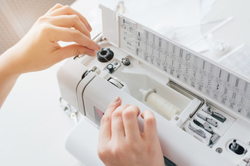 Fototapeta premium Seamstress adjusts the sewing machine to work