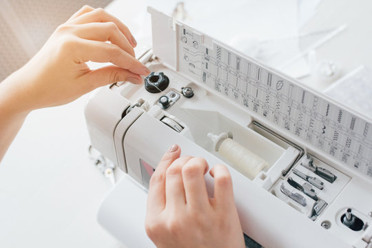 Seamstress adjusts the sewing machine to work