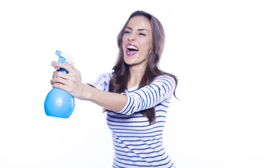 House cleaning. A cheerful beautiful and energetic young woman with a nebulizer in her hands is cleaning her apartment. Means to clean glass.