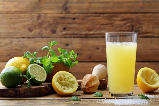 succo di limone e lime in bicchiere su sfondo tavolo legno