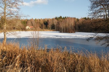 View of the winter landscape with a pond and a small island in Rumburk, Czech Republic