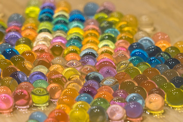 Fototapeta na wymiar Bright wet balls of gidrogel as background, close-up photo