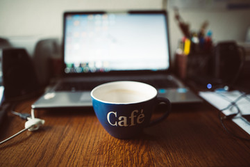 Leere Kaffeetasse vor Laptop
