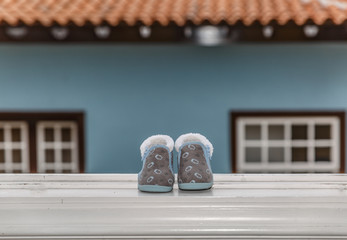 Fototapeta na wymiar Baby shoes on the ledge of a window on a winter day