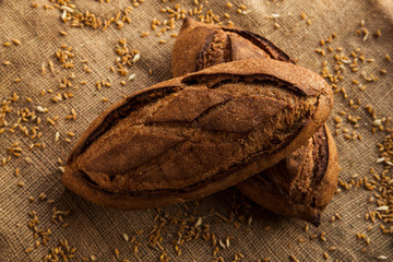 Loaf of homemade bread on sackcloth with rye.
