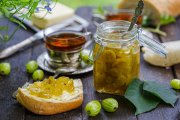 Green gooseberry jam on a wooden table