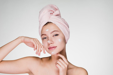 Woman with towel on her head after showering cream on face