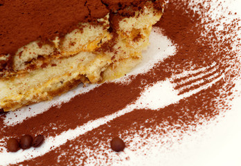 Cake tiramisu with an image of a fork on a plate sprinkled with chocolate