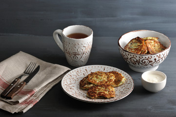 fritters of zucchini with tea on rusticbackground