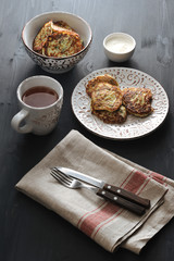 fritters of zucchini with tea on rusticbackground
