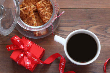 Cup of coffee, cookies and romantic gift on a table