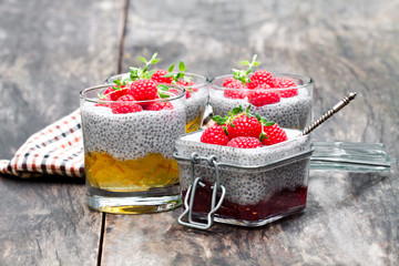 Chia  seed puddings with orange marmalade and raspberries on wooden table