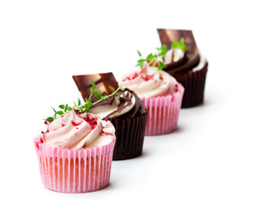 Chocolate  cupcakes with fresh raspberries and cream isolated on white