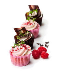 Chocolate  cupcakes with fresh raspberries and cream isolated on white