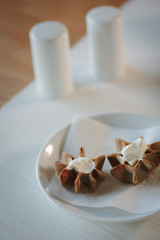 Nice appetizer snacks - tartlets on a white ceramic plate.