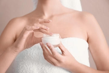 Young woman with jar of hand cream, closeup