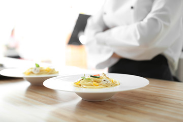 Plate with tasty pasta on table, closeup. Dish from chef