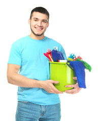 Young man with cleaning supplies on white background