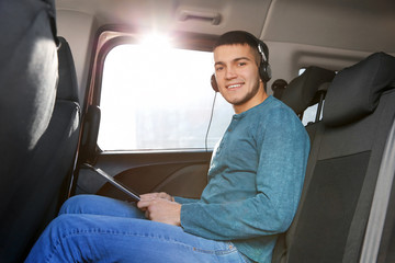 Man listening to audiobook through headphones in car