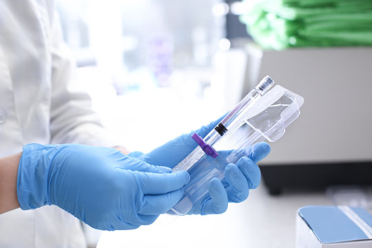Cosmetologist with new syringe in salon, closeup