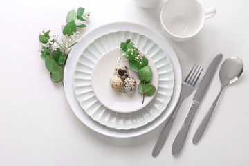 Beautiful festive Easter table setting with quail eggs on white background