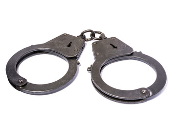 black metal handcuffs with small scratches on white background