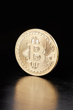 Golden Bitcoin, cryptocurrency coin on black, clipping path