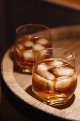 Glass of whiskey on wooden background close up