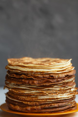 High stack of classic Russian thin pancakes. Rustic style. Traditional for the Russian pancake week Maslenitsa