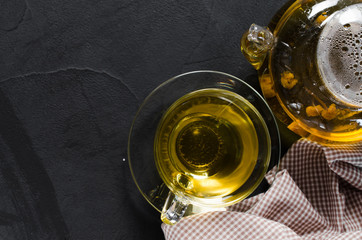 Fototapeta na wymiar Cup of delicious herbal tea and glass teapot.