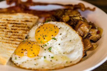fried eggs and potatoes with bacon