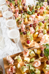 Furshet. Table top full of glasses of sparkling white wine with canapes and antipasti in the background. champagne bubbles