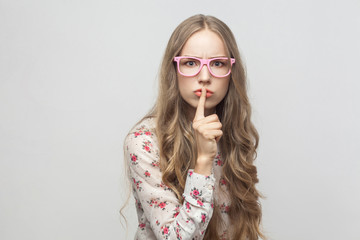 Expressing girl, showing quiet sign at camera.