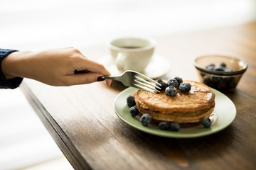 Woman eating pancakes for breakfast