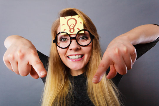 Woman having light bulb mark on forehead thinking