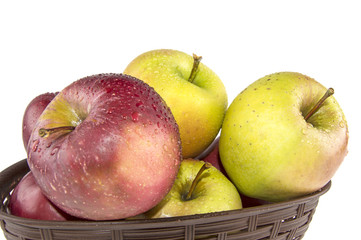 wet apples in a basket on a white background