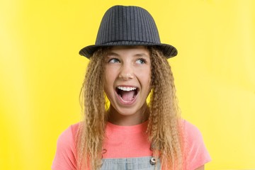 Delight, happiness, joy, victory, success and luck. Teen girl on a yellow background.
