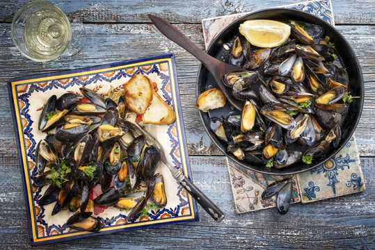 Traditional barbecue Italian blue mussel in white wine as top view on a plate