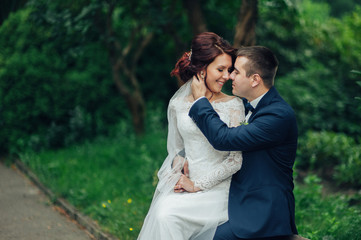 beautiful gorgeous bride and groom walking in sunny park and kis