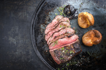 Barbecue caveman wagyu roast beef sliced with Yorkshire pudding as top view on a tray with copy...