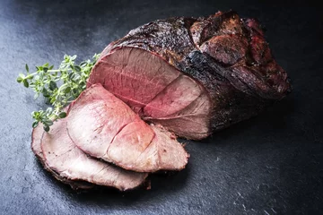  Barbecue dry aged haunch of venison with herbs as close-up on a board © HLPhoto