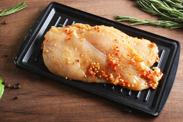 chicken breast in marinade spice, board, rosemary