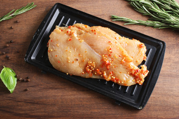 chicken breast in marinade spice, board, rosemary