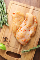 chicken breast in marinade spice, board, rosemary