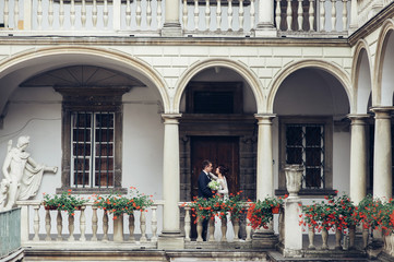 Obraz premium Beautiful bride and groom embracing and kissing on their wedding