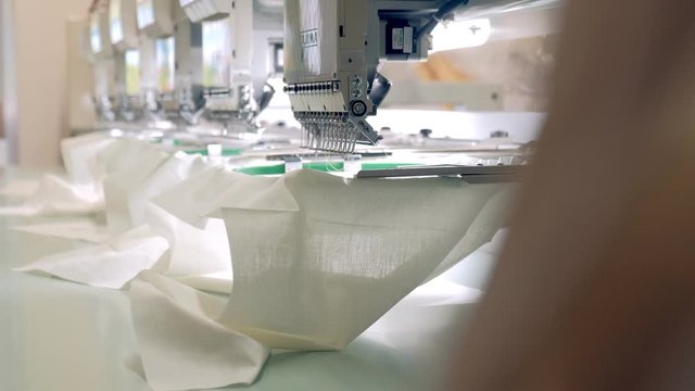 Textile - Professional and industrial embroidery machine. Machine embroidery is an embroidery process whereby a sewing machine or embroidery machine is used to create patterns on textiles.