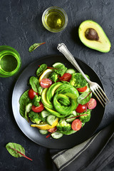 Vegetable salad with avocado, cucumber, cherry tomato, chard leaves and broccoli.Top view with copy space.