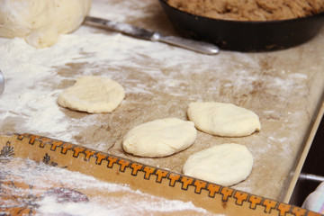 baking pies in home kitchen. cooks pies. Home cooked food. omemade mold cakes of the dough in the ederly women's hands. The process of making pie dough by hand
